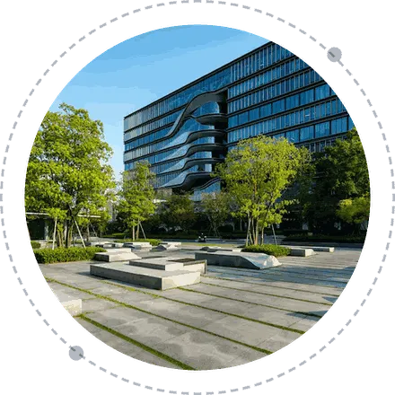 Modern glass office building with landscaped courtyard and trees