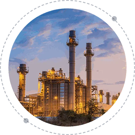 Industrial plant with tall stacks lit at dusk