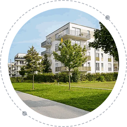 Apartment block with balconies beside a lawn and trees